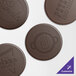 Four brown circular coasters with chocolate logos.