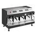 An automatic stainless steel espresso machine with three group heads and multiple control switches.