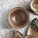 A brown Libbey Hedonite porcelain bowl on a marbled surface.