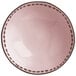 A close-up of a pink stoneware serving bowl with brown dots.