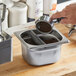 A person knocking ground coffee into a metal container using the Choice espresso knock box.