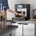 A person using a TurboChef Eco rapid cook oven on a kitchen counter.