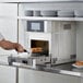 A man using a TurboChef Eco rapid cook oven to prepare food.