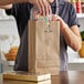 A man holding a brown Duro paper bag full of candy.