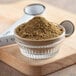 A bowl of Regal Ground Cumin powder on a cutting board.