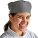 A woman wearing a Choice Houndstooth chef skull cap.