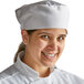 A woman wearing a white mesh top chef skull cap.