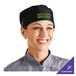 A woman wearing a black Choice mesh chef's hat in a professional kitchen.