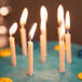 A white cake with Creative Converting white spiral candles lit on top.