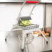 A Vollrath Redco Lettuce King vegetable cutter on a counter with a bowl of lettuce.