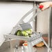 A person using a Vollrath Redco vegetable cutter to slice lettuce.