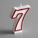 A white candle with a red outlined number 7.