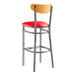 A Lancaster Table & Seating bar stool with a red cushion and cherry wood back.