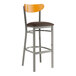 A Lancaster Table & Seating bar stool with a brown vinyl seat and cherry wood back.