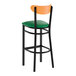 A bar stool with a black metal frame, green vinyl seat, and a cherry wood backrest.