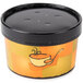 A round white paper container with a black lid filled with soup.