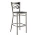 A Lancaster Table & Seating metal cross back bar stool with a black wood seat.