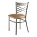 A Lancaster Table & Seating metal cross back chair with a light brown vinyl padded seat.
