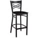 A Lancaster Table & Seating black metal bar stool with a black wood seat and back.