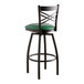 A Lancaster Table & Seating black cross back swivel bar stool with a green vinyl padded seat.