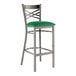 A Lancaster Table & Seating metal bar stool with a green vinyl padded seat.