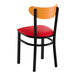 A black metal chair with a red vinyl seat and a curved cherry wood backrest.