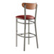 A Lancaster Table & Seating bar stool with a red vinyl seat and wood back.