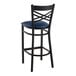 A Lancaster Table & Seating black cross back bar stool with a navy blue padded seat.