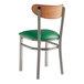 A Lancaster Table & Seating Boomerang chair with a green vinyl seat and metal back.