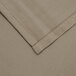 A close-up of a beige cloth with a white hem.