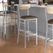 Lancaster Table & Seating bar stools with dark brown vinyl seats and driftwood backs on a table in a pub interior.