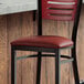 A Lancaster Table & Seating burgundy vinyl padded seat for metal frame seating.