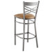 A Lancaster Table & Seating metal bar stool with a light brown cushioned seat.