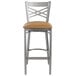 A Lancaster Table & Seating metal bar stool with a light brown vinyl seat.