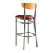 A Lancaster Table & Seating bar stool with a burgundy vinyl seat and cherry wood back.