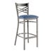 A Lancaster Table & Seating metal bar stool with a navy blue padded seat.