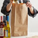 a brown paper bag with a black handle