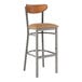 A Lancaster Table & Seating bar stool with a brown cushioned seat and wood back.