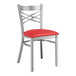 A Lancaster Table & Seating clear coat finish cross back chair with a red vinyl padded seat.