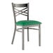 A Lancaster Table & Seating metal cross back chair with a green vinyl seat