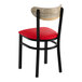 A black metal chair with a red vinyl seat and a curved driftwood-finish wooden backrest.
