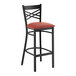 A black metal bar stool with a cross back design and a burgundy vinyl padded seat.
