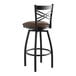 A Lancaster Table & Seating black cross back swivel bar stool with dark brown vinyl padded seat.