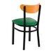 A black metal chair with a green vinyl seat and a curved cherry wood backrest.