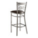 A metal bar stool with a cross back design and a dark brown padded vinyl seat.