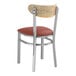 A Lancaster Table & Seating metal chair with a red vinyl cushion.