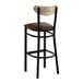 A black metal bar stool with a dark brown vinyl seat and a curved driftwood-finish backrest.