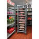 A Cambro sheet pan rack with food on large metal shelves.