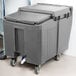 A grey plastic Cambro mobile ice bin with wheels.