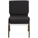 A black church chair with gold metal legs and a dot pattern.